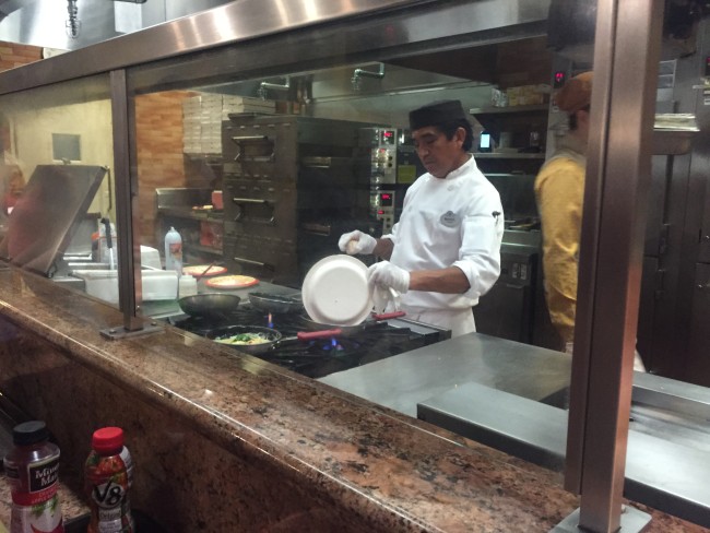 Chef adding ingredients to hot pan at Riverside Mill Food Court